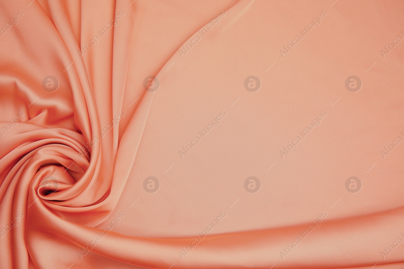 Image of Delicate pale orange silk fabric as background, top view. Space for text