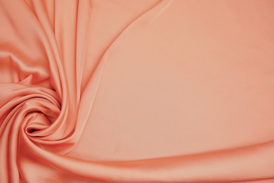 Image of Delicate pale orange silk fabric as background, top view. Space for text