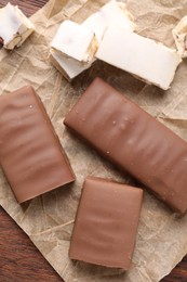 Tasty chocolate bars and nougat on table, top view