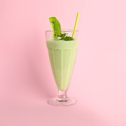 Photo of Tasty fresh milk shake with kiwi on pink background