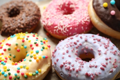 Photo of Sweet delicious glazed donuts on table, closeup