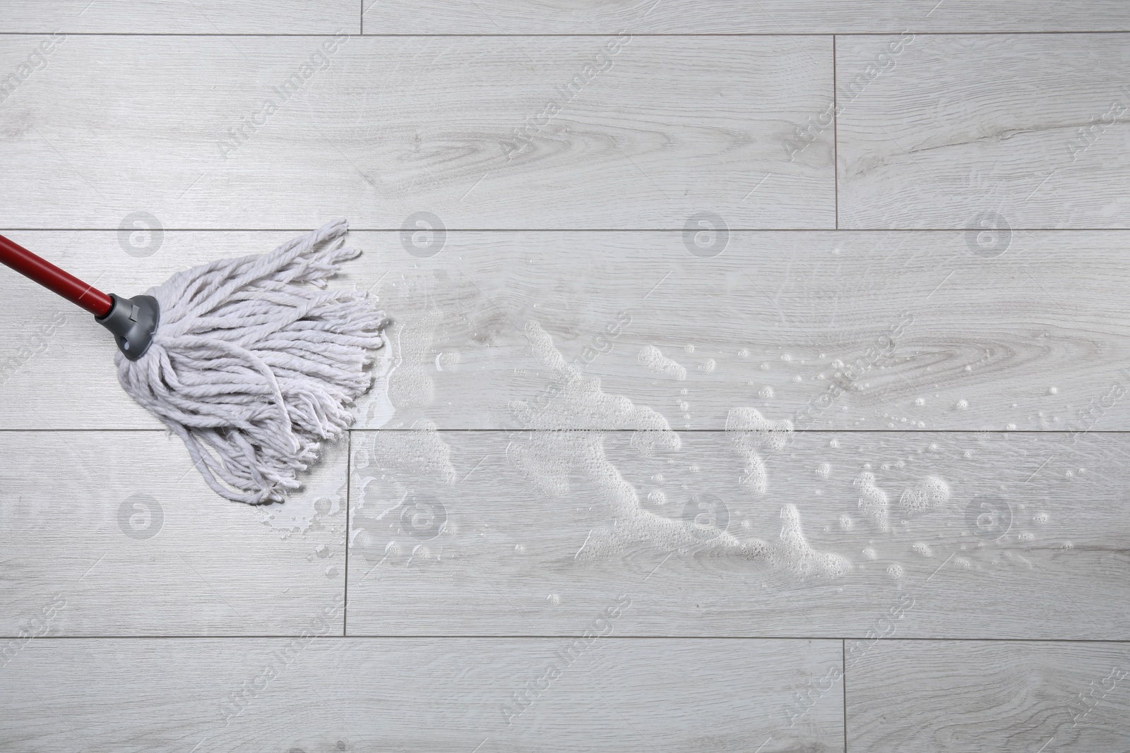 Photo of Cleaning wooden floor with mop, above view. Space for text