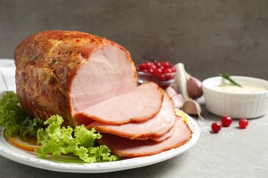 Delicious ham served with garnish on grey table