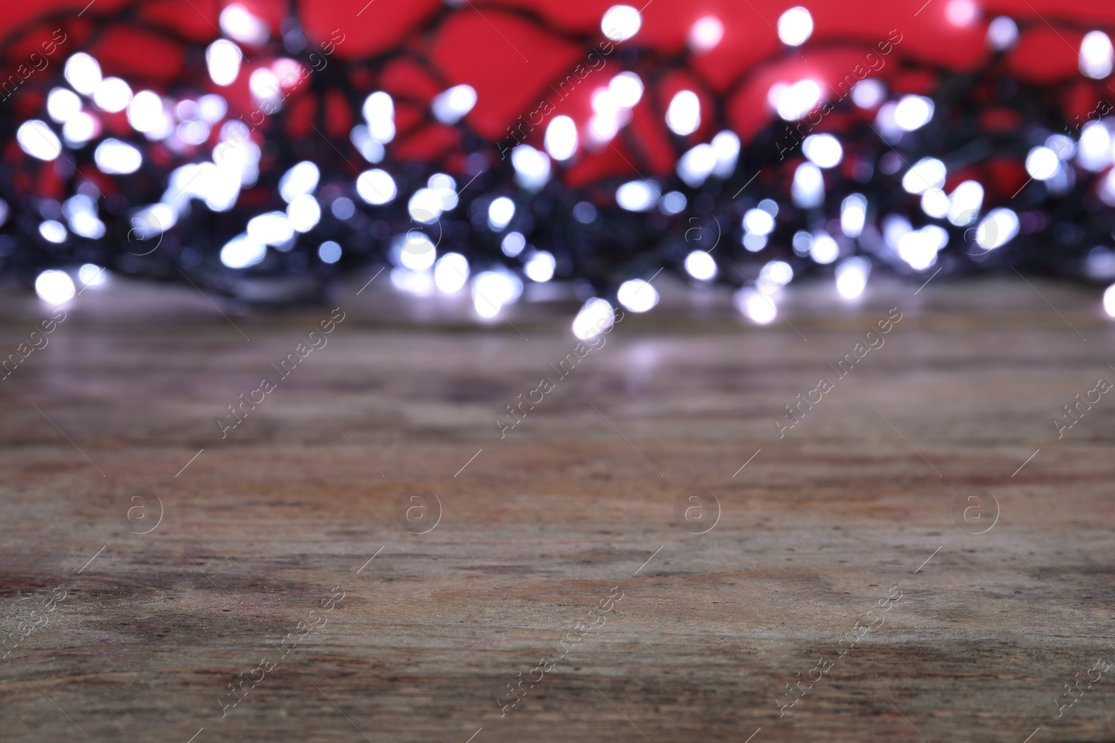 Photo of Wooden table and blurred Christmas lights on background