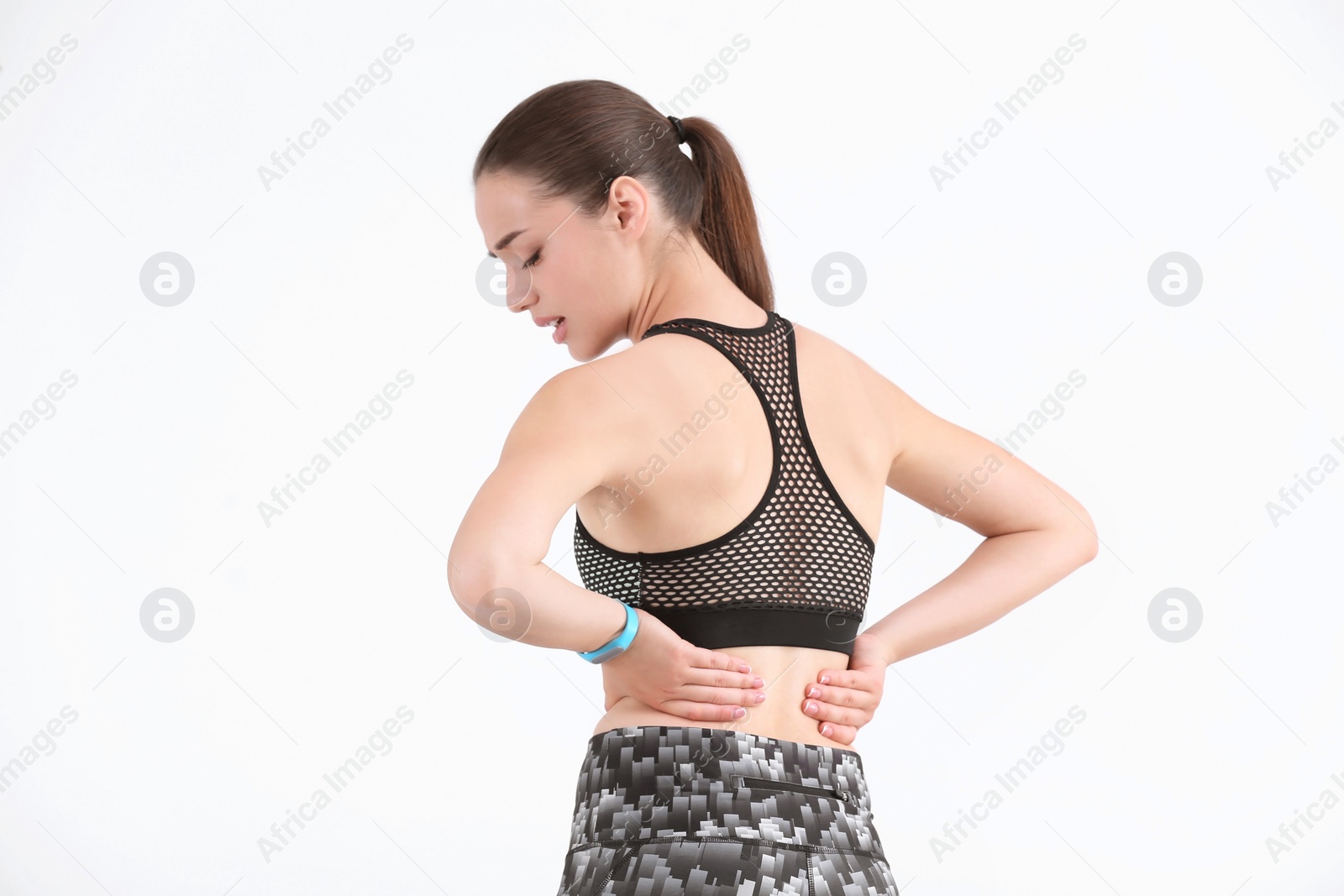 Photo of Woman in sportswear suffering from back pain on white background