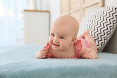 Photo of Cute little baby lying on bed at home