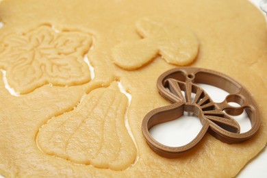 Cookie cutter and dough on white table, closeup