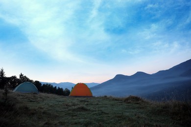 Photo of Camping tents on mountain slope in morning