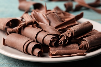 Photo of Plate with chocolate curls on table, closeup