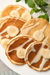 Photo of Tasty pancakes with sliced banana served on grey table, closeup
