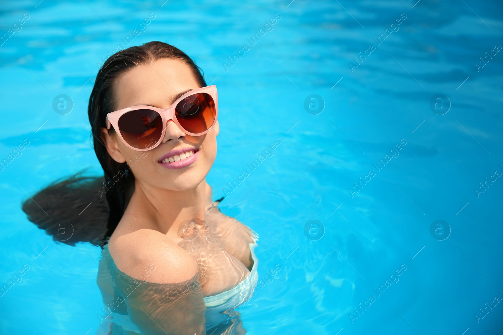 Photo of Beautiful young woman in blue swimming pool