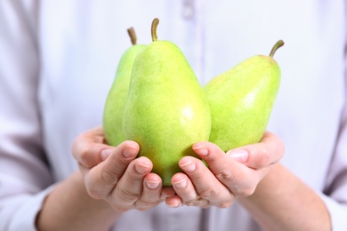 Photo of Woman holding fresh ripe green pears, closeup