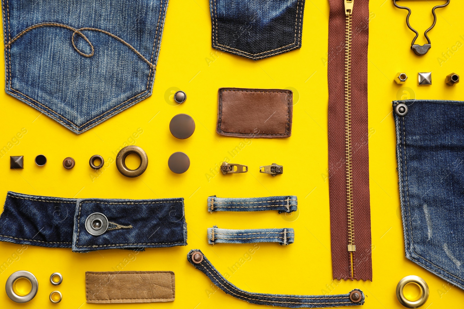 Photo of Flat lay composition with garment accessories and cutting details for jeans on yellow background