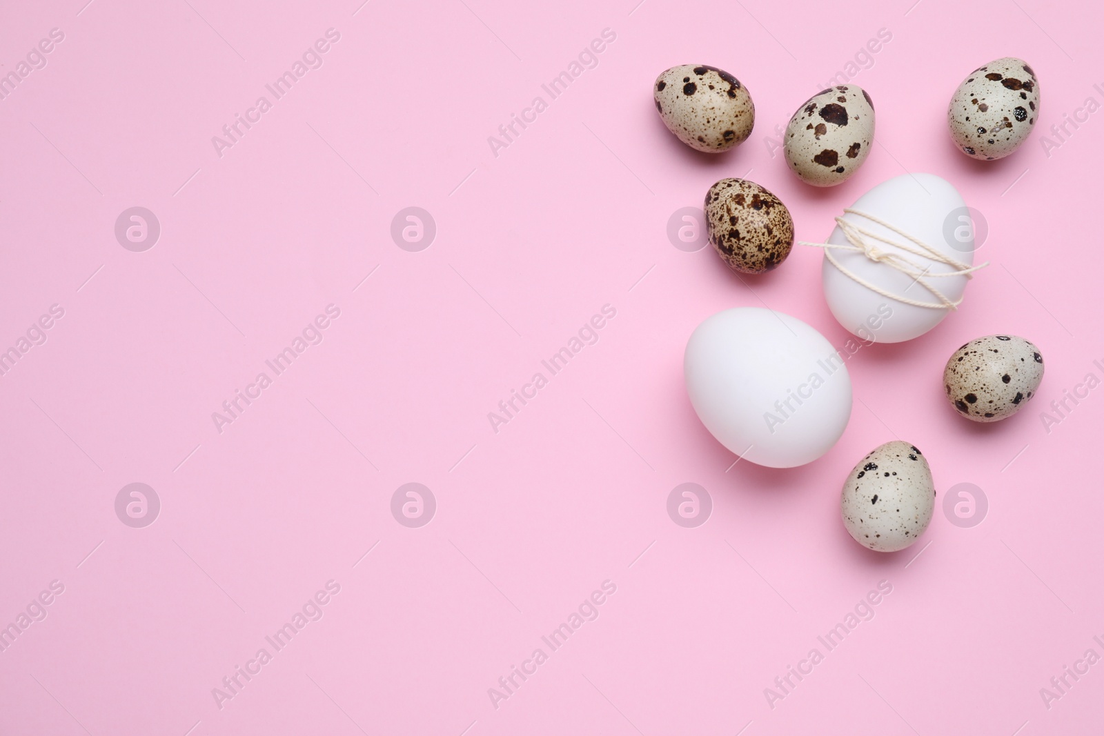 Photo of Easter eggs on pink background, flat lay. Space for text