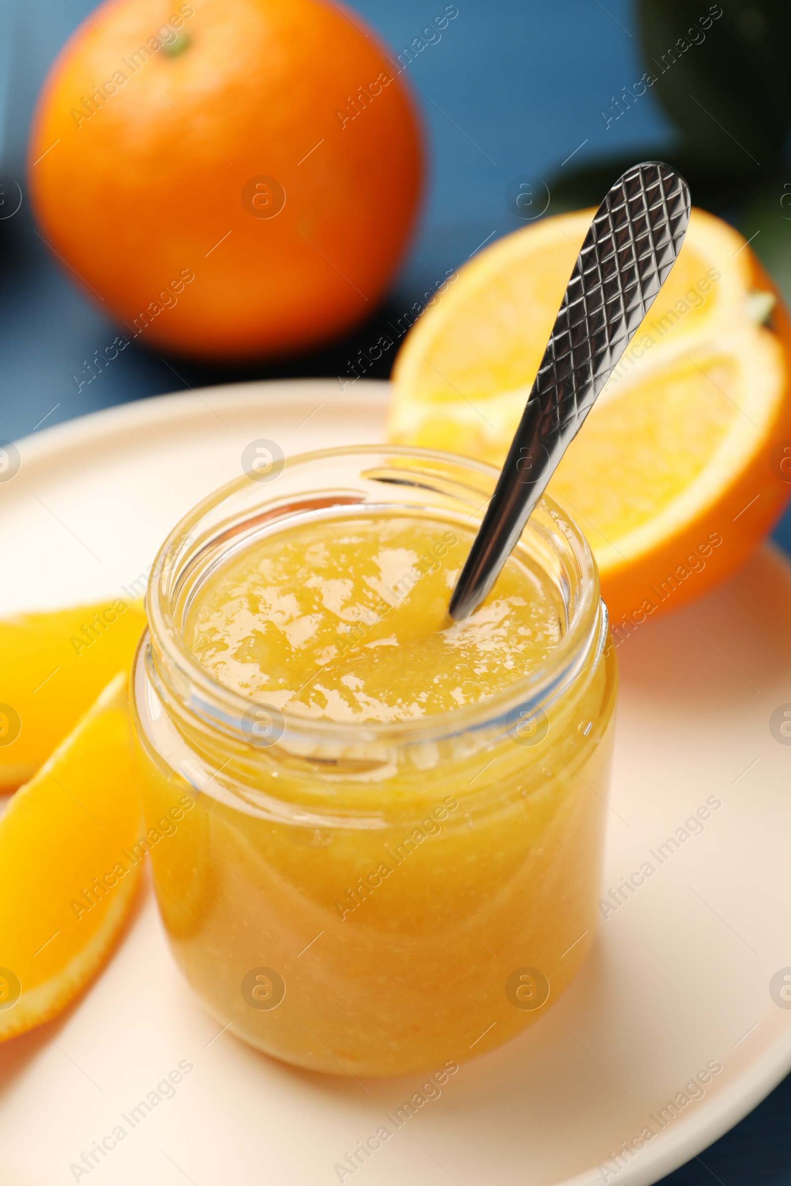 Photo of Delicious orange marmalade in jar on plate