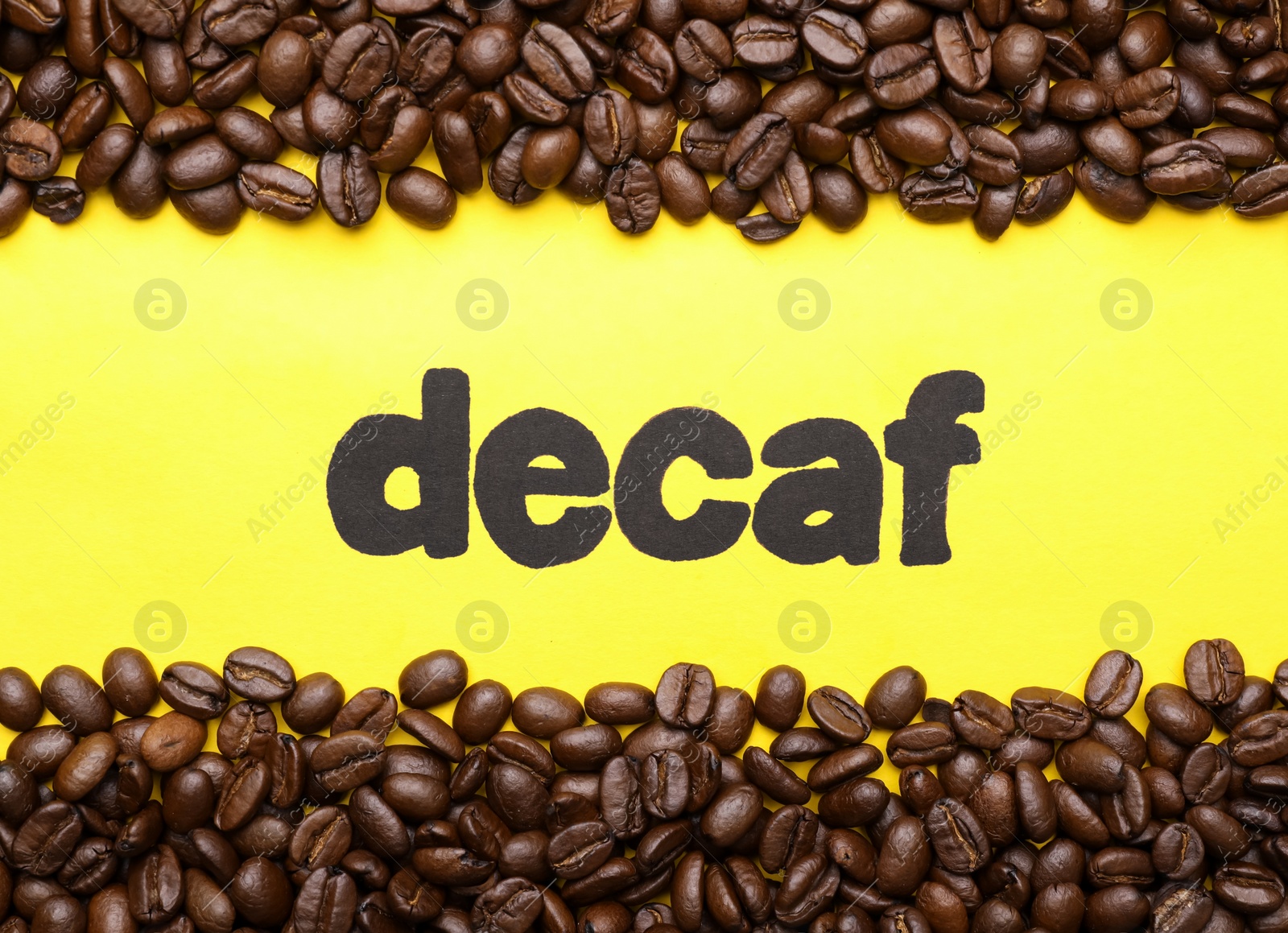 Photo of Word Decaf and coffee beans on yellow background, flat lay