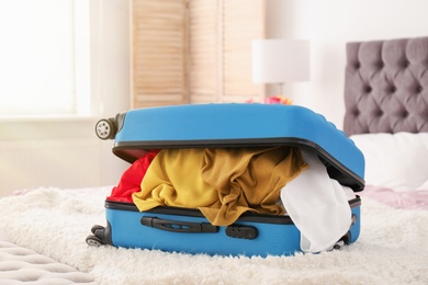 Photo of Packed travel suitcase on bed