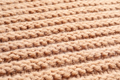 Photo of Beige winter sweater as background, closeup view