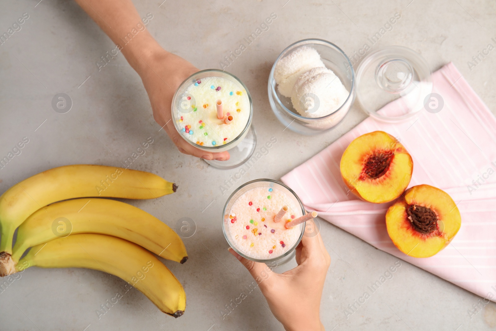 Photo of Women with glasses of delicious milk shakes at table, top view