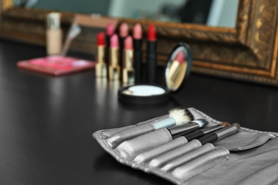 Photo of Brushes on dressing table in makeup room, closeup