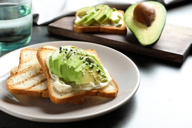 Photo of Toasted bread with avocado and seeds on table