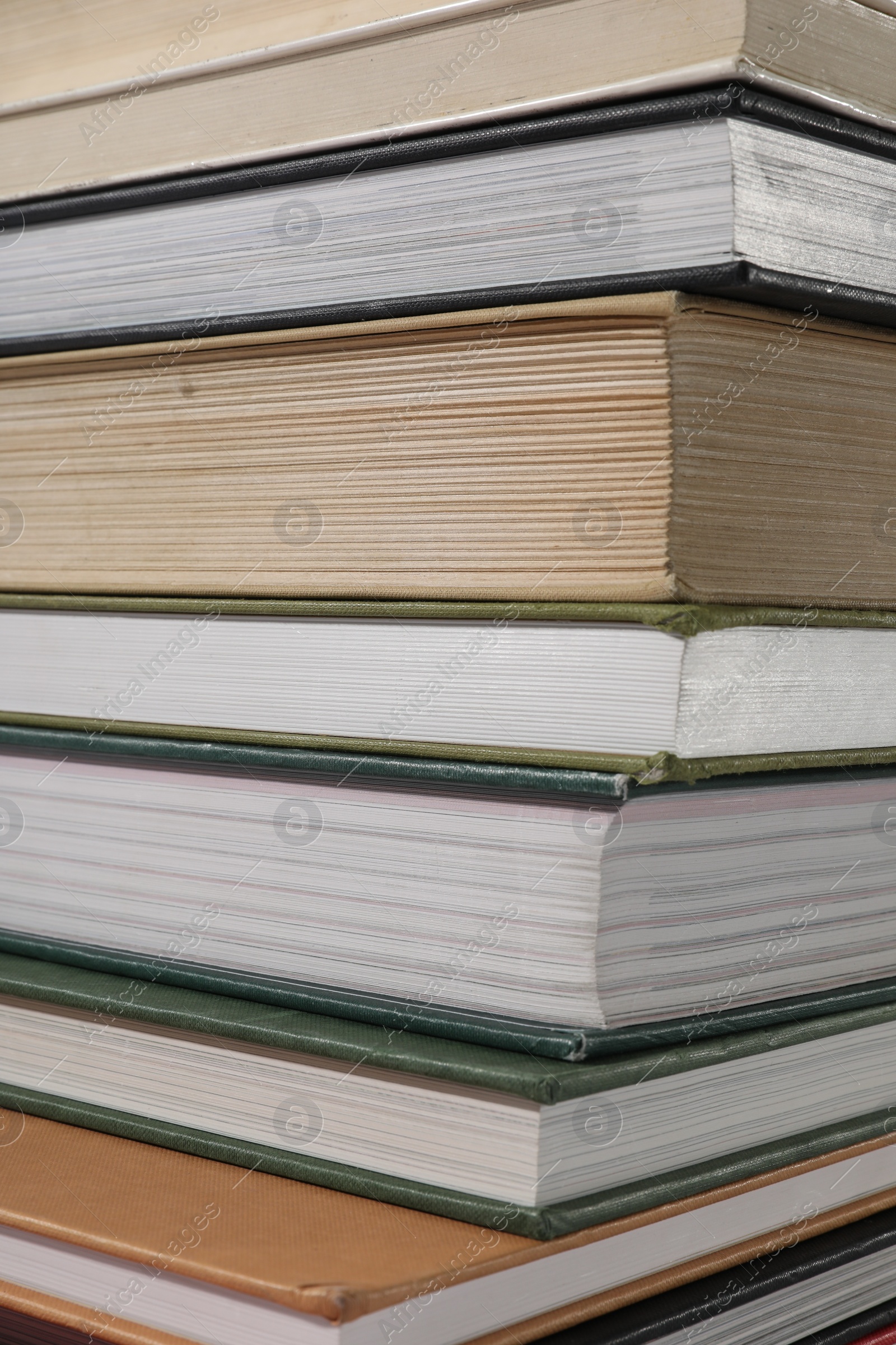 Photo of Stack of many different hardcover books as background, closeup