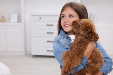 Photo of Little child with cute puppy at home, space for text. Lovely pet