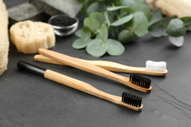 Photo of Toothbrushes made of bamboo on black stone table