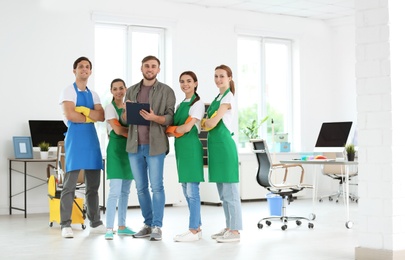 Team of professional janitors in uniform indoors