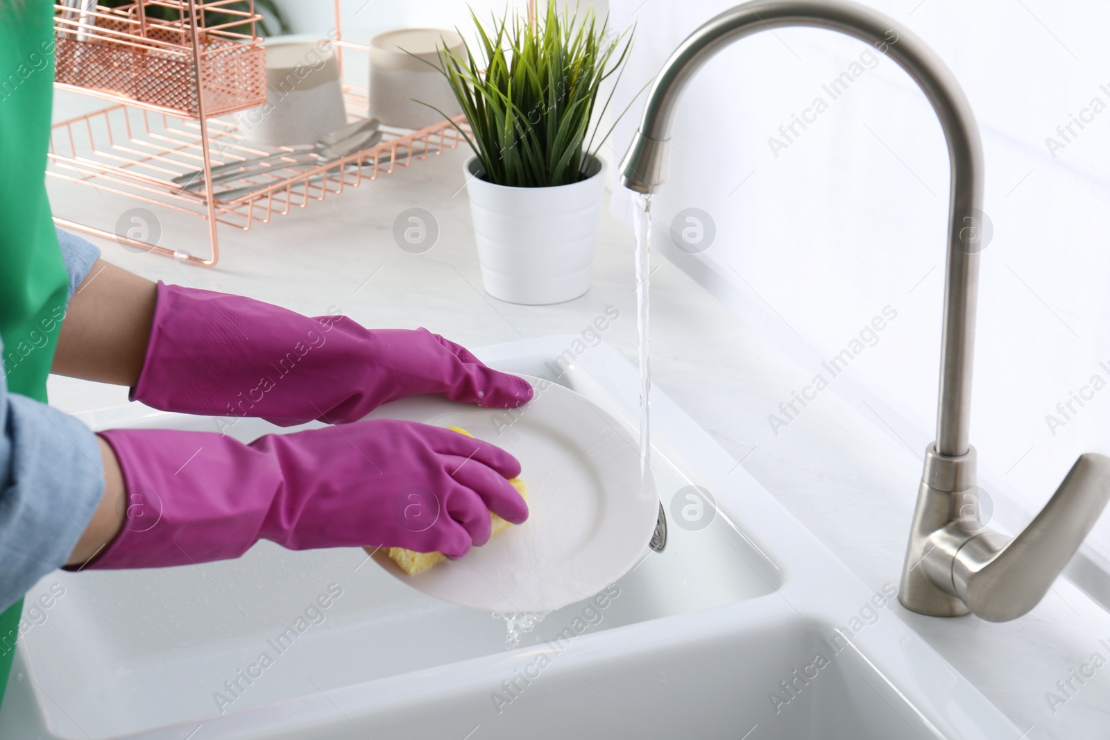 Photo of Woman washing plate in modern kitchen, closeup