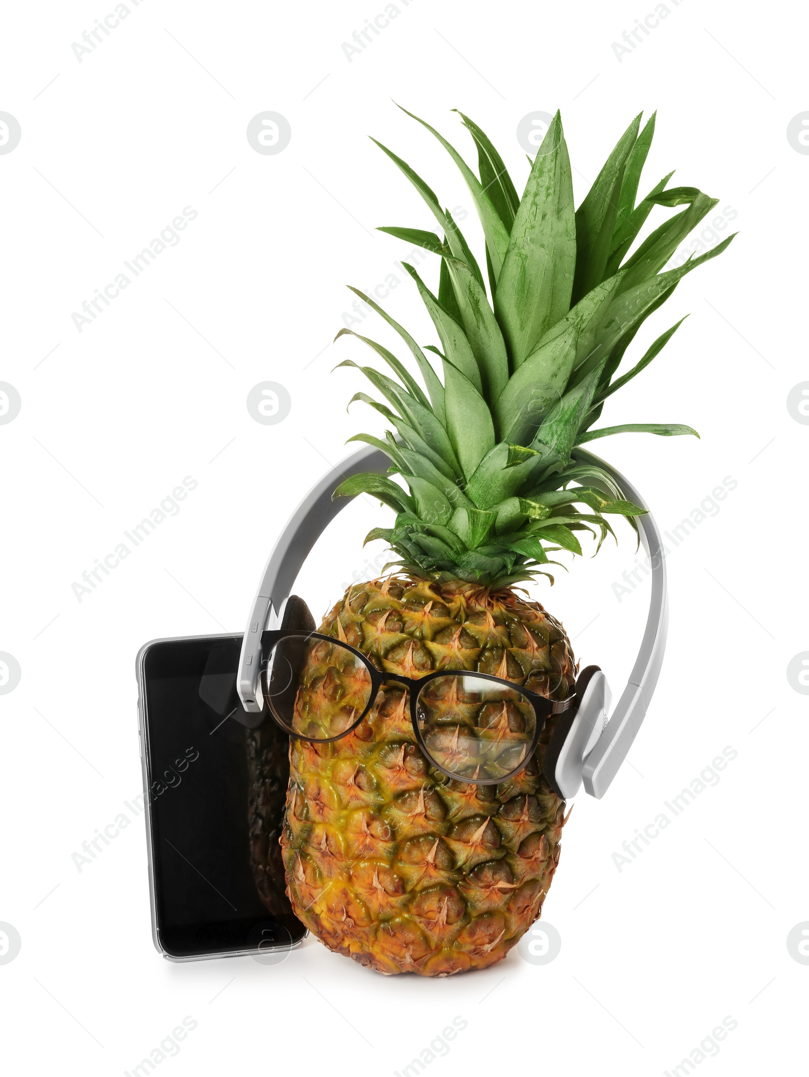 Photo of Fresh pineapple with headphones, smart phone and glasses on white background