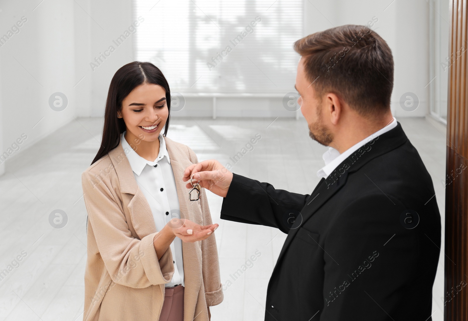 Photo of Real estate agent giving key to client in new apartment