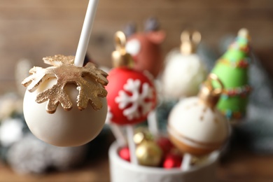 Delicious Christmas ball cake pop on blurred background, closeup