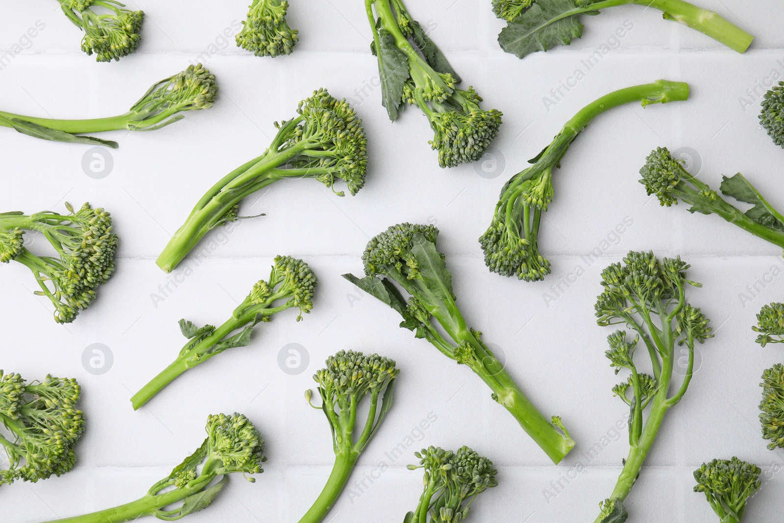 Photo of Fresh raw broccolini on white table, flat lay. Healthy food