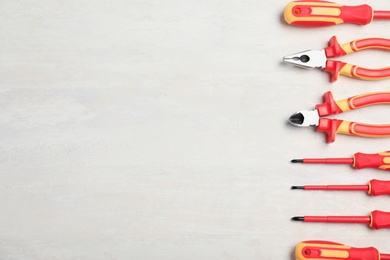 Photo of Flat lay composition with electrician's tools and space for text on light background