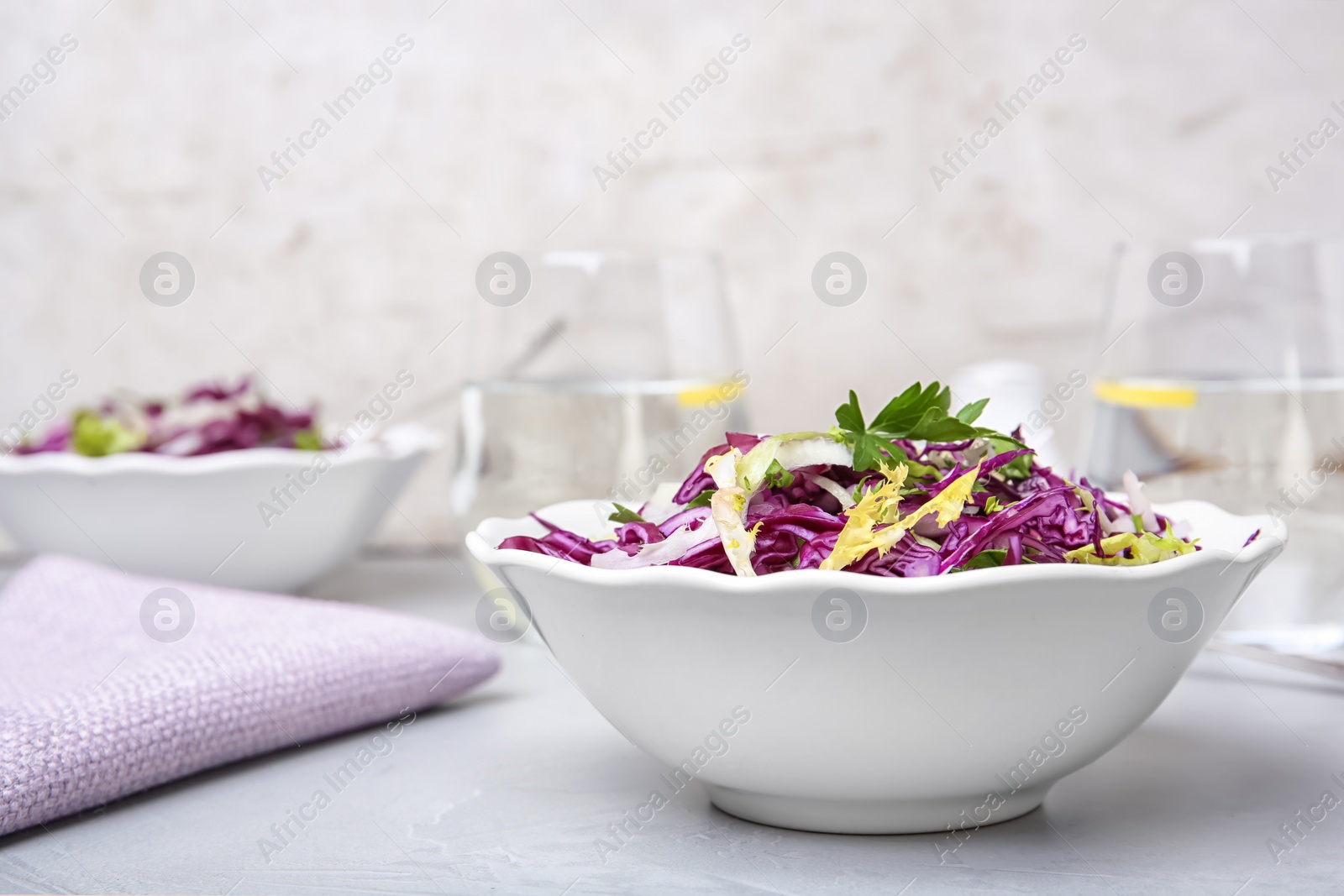 Photo of Bowl with chopped red cabbage on table