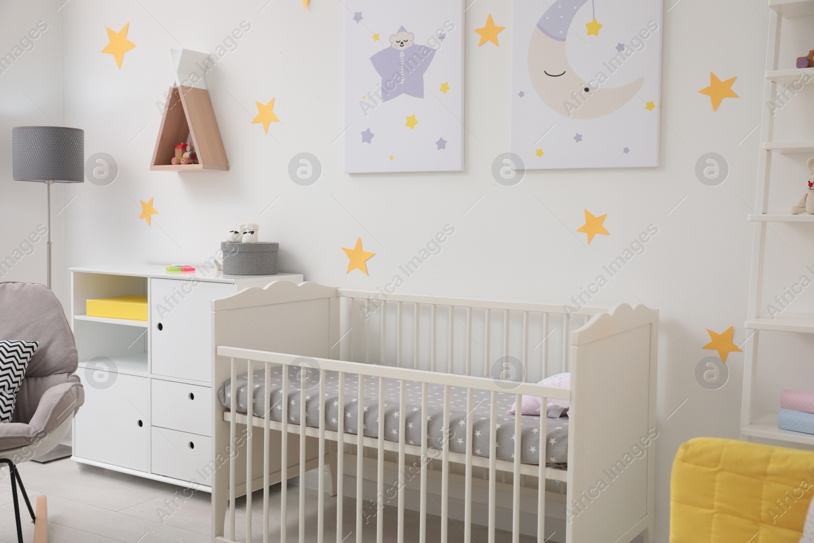 Photo of Stylish baby room interior with crib and decor elements