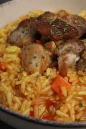 Photo of Delicious pilaf with meat in white bowl, closeup