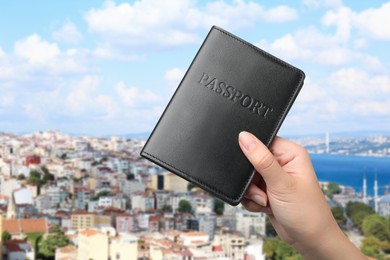 Image of Woman holding passport and beautiful view of city near sea on background