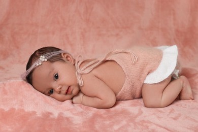 Adorable newborn baby lying on pink soft blanket