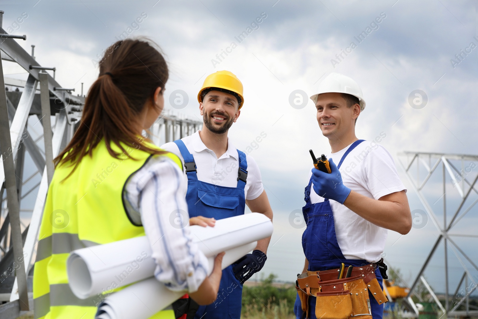 Photo of Professional engineers working on installation of electrical substation outdoors