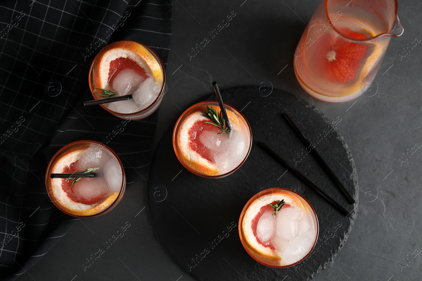 Photo of Flat lay composition with glasses of grapefruit cocktails on grey background