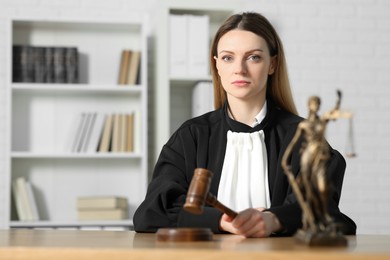 Photo of Judge striking mallet at wooden table indoors, selective focus. Space for text