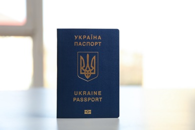 Ukrainian travel passport on table against blurred background. International relationships