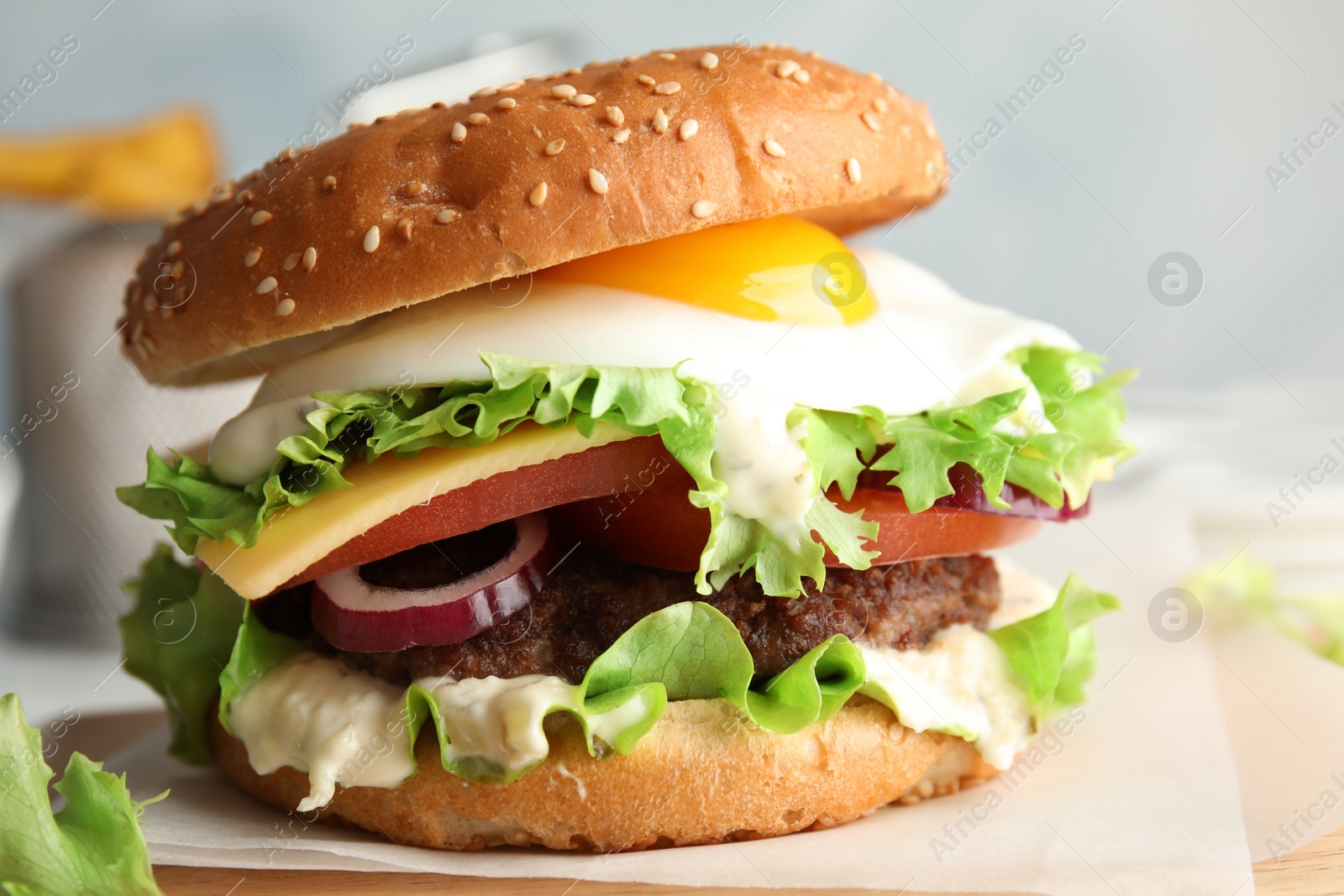 Photo of Tasty burger with fried egg on wooden board