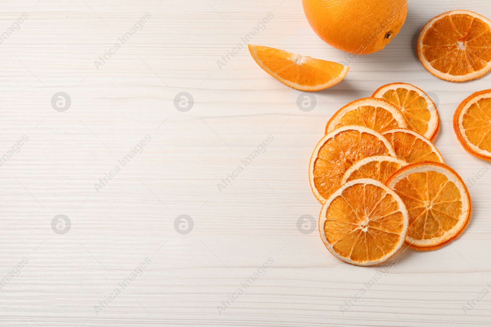 Photo of Dry and fresh orange slices on white wooden table, flat lay. Space for text