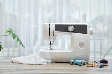 Sewing machine on table near window indoors