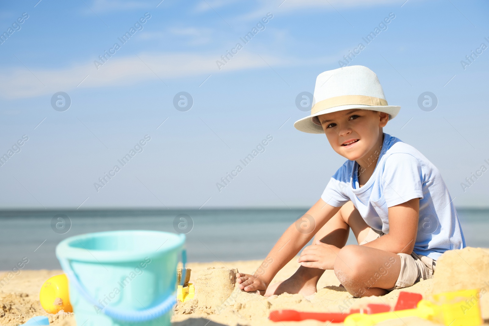 Photo of Cute little boy playing with plastic toys on sandy beach