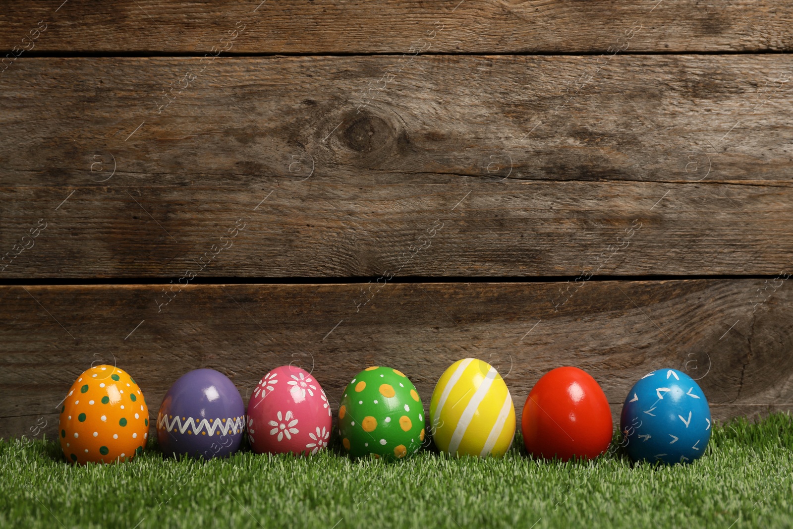 Photo of Decorated Easter eggs on green grass. Space for text