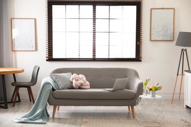 Interior of cozy living room with grey sofa